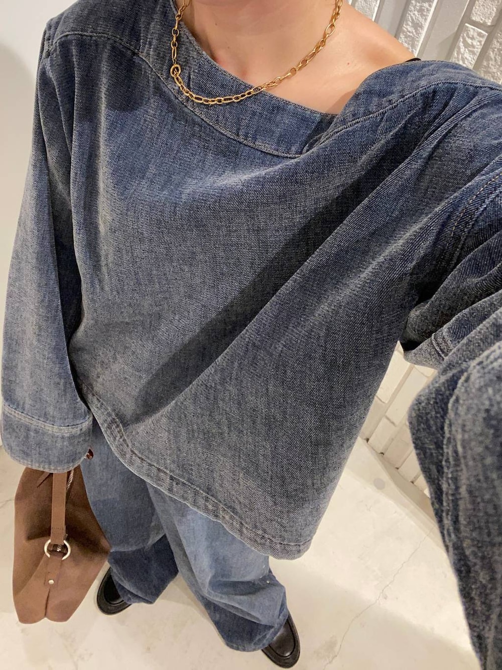 ブラック系のローファー、ブルー系のデニムパンツ、ブルー系のTシャツ/カットソーを着用したレディースの秋コーディネートの7枚目の写真