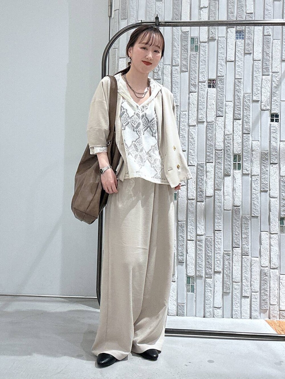 ベージュ系のその他パンツ、ベージュ系のテーラードジャケット、ブラウン系のショルダーバッグを着用したレディースの春コーディネートの2枚目の写真