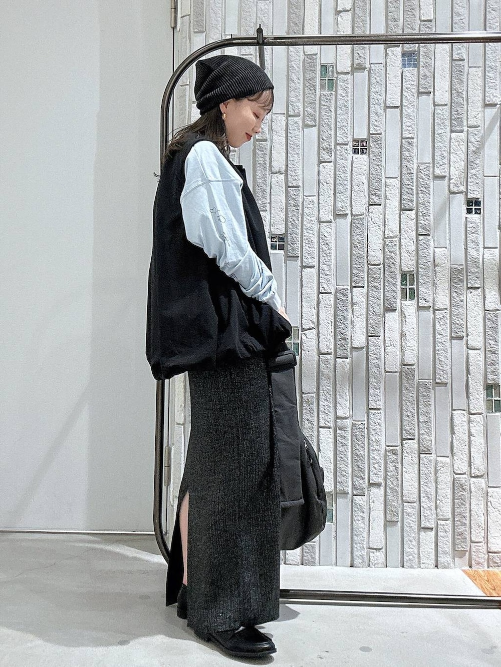 ブルー系のTシャツ/カットソー、グレー系のショルダーバッグ、ブラック系のベストを着用したレディースの秋コーディネートの3枚目の写真