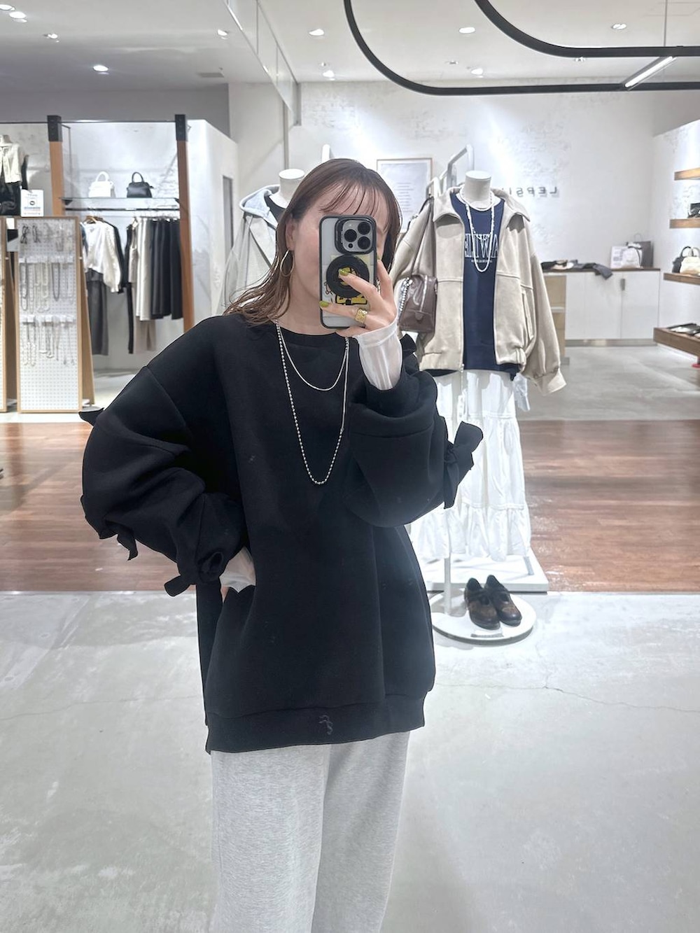 ブラック系のスウェット、ホワイト系のTシャツ/カットソー、グレー系のスウェットパンツを着用したレディースの冬コーディネートの2枚目の写真