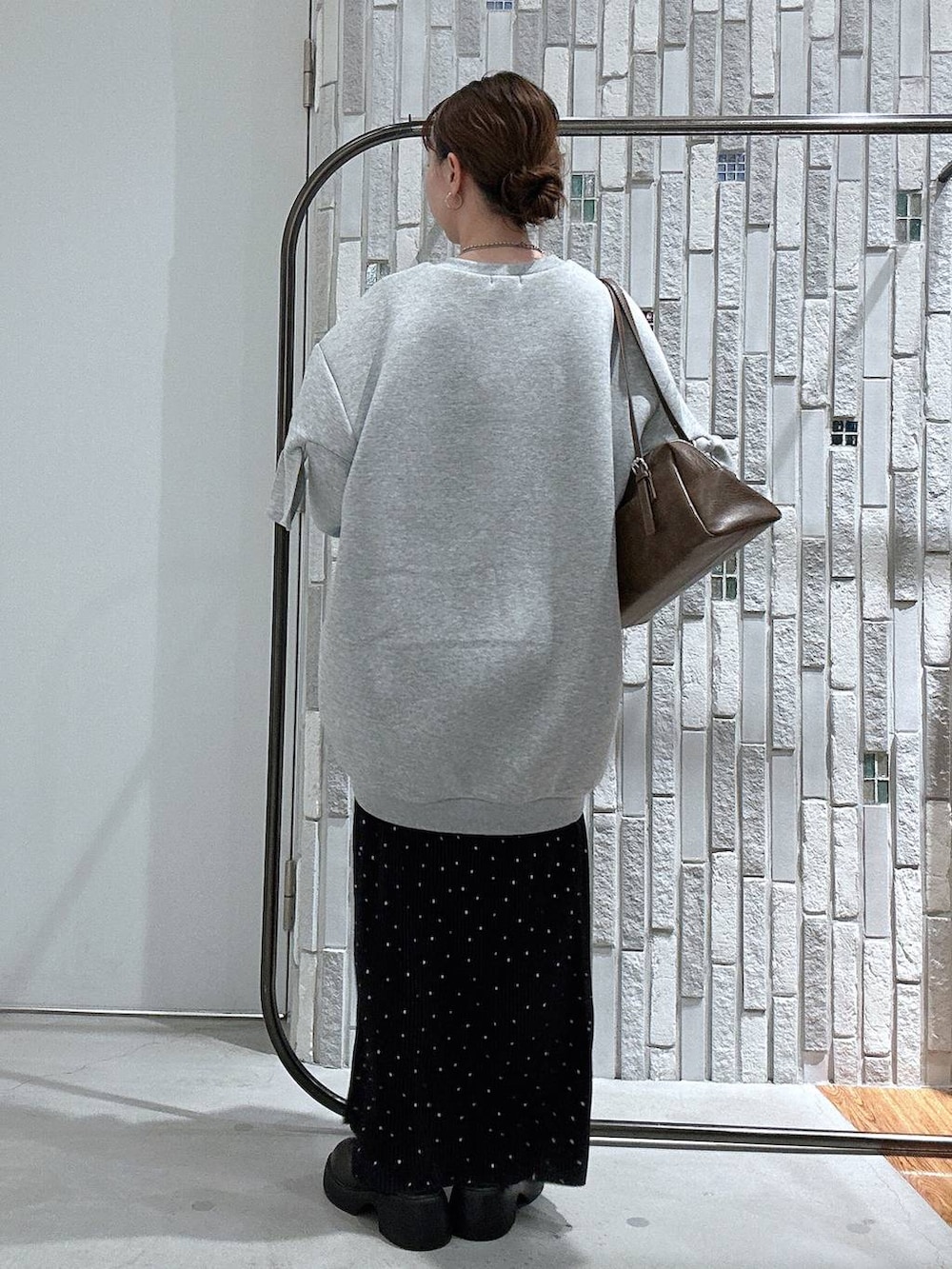 ブラウン系のサンダル、ブラウン系のボストンバッグ、グレー系のスウェットを着用したレディースの冬コーディネートの4枚目の写真