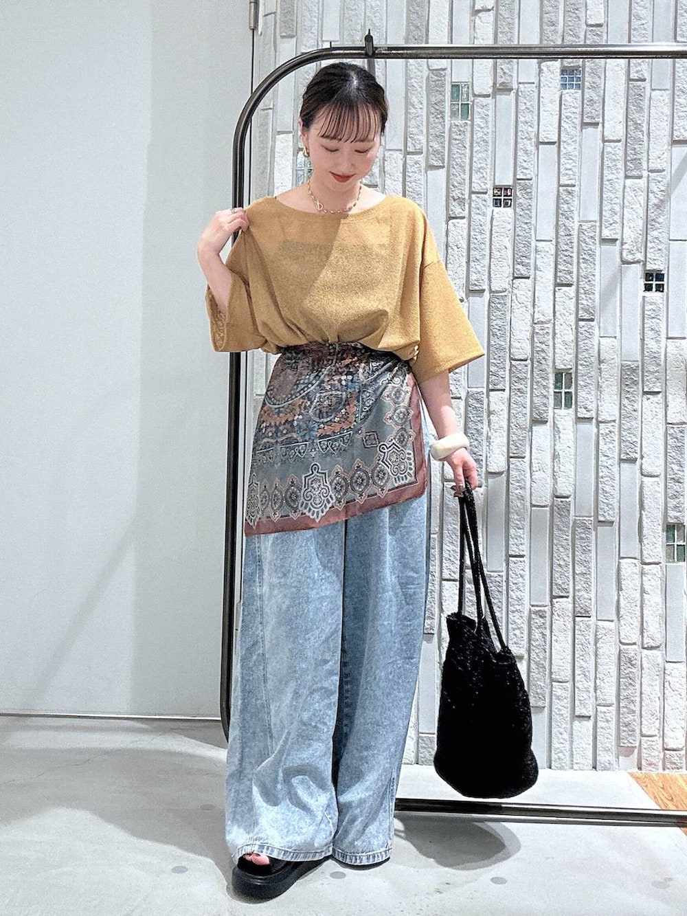 ブルー系のデニムパンツ、ブラック系のサンダル、グレー系のショルダーバッグを着用したレディースの春コーディネートの4枚目の写真