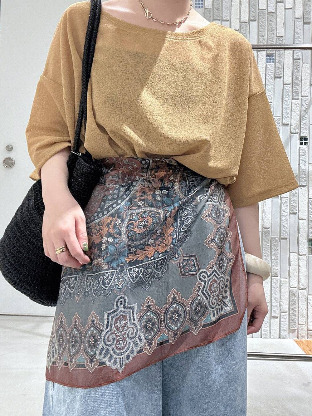 ブルー系のデニムパンツ、ブラック系のサンダル、グレー系のショルダーバッグを着用したレディースの春コーディネートの6枚目の写真