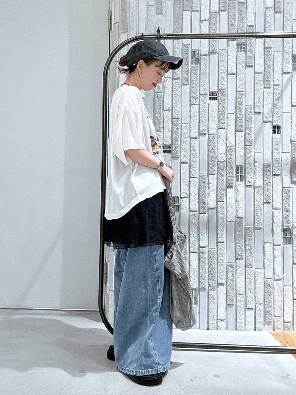 グレー系のトートバッグ、ホワイト系のTシャツ/カットソー、その他のサンダルを着用したレディースの夏コーディネートの4枚目の写真