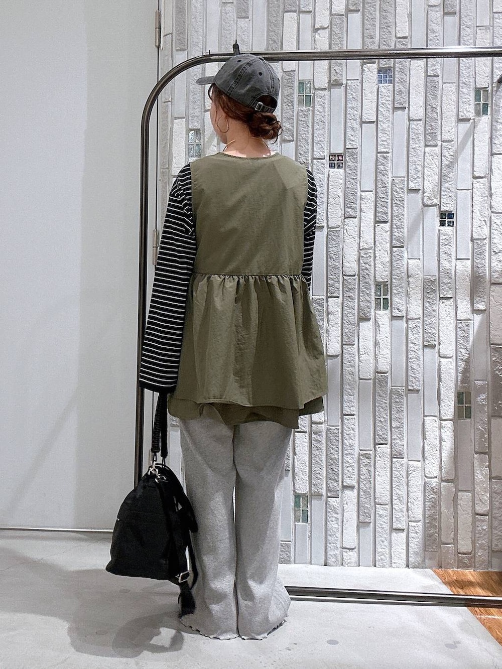 ブラック系のショルダーバッグ、ブラック系のTシャツ/カットソー、ブラック系のスニーカーを着用したレディースの冬コーディネートの3枚目の写真