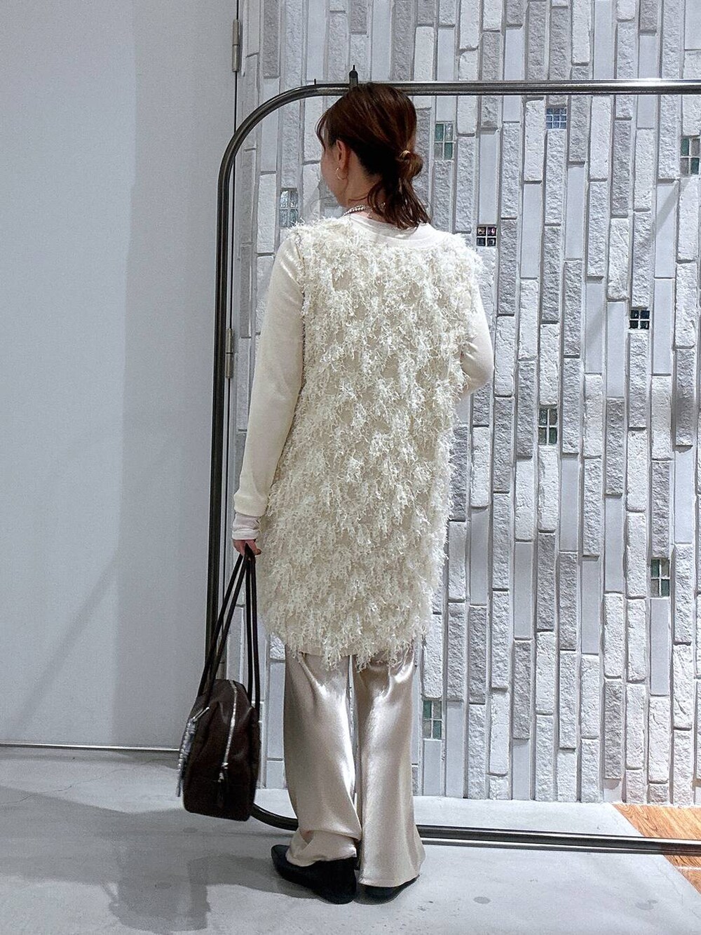 ホワイト系のTシャツ/カットソー、ブラウン系のボストンバッグ、ホワイト系のその他パンツを着用したレディースの春コーディネートの4枚目の写真