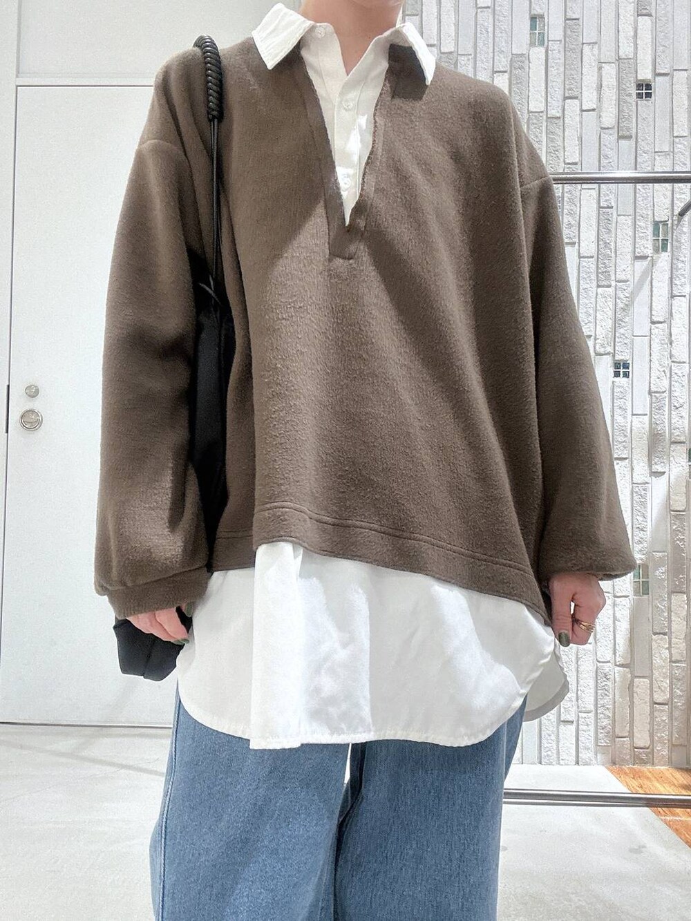 ブラック系のトートバッグ、ブルー系のデニムパンツ、ブラック系のブーツを着用したレディースの冬コーディネートの5枚目の写真