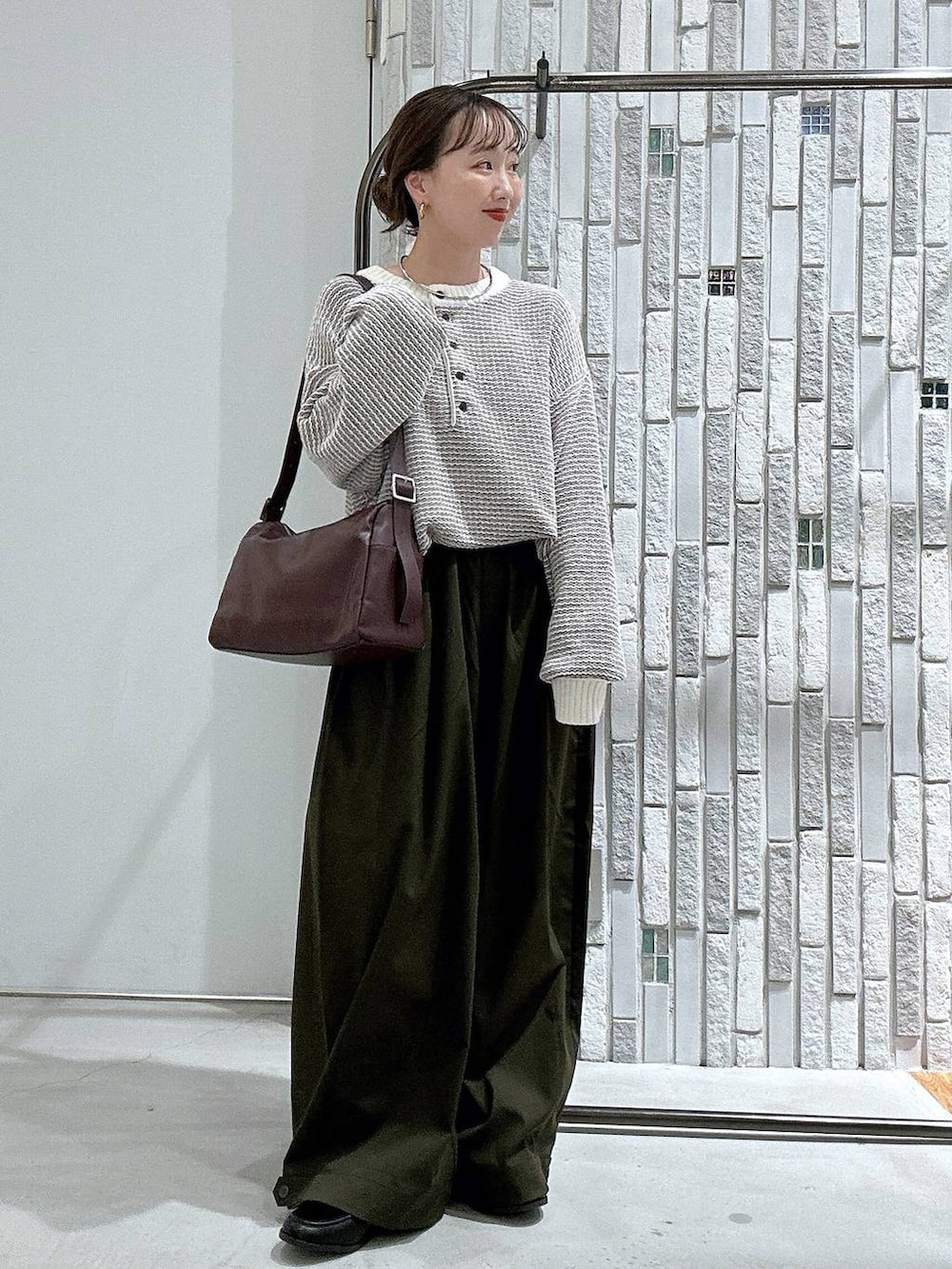 ブラック系のローファー、グリーン系のその他パンツ、ホワイト系のニット/セーターを着用したレディースの秋コーディネートの2枚目の写真