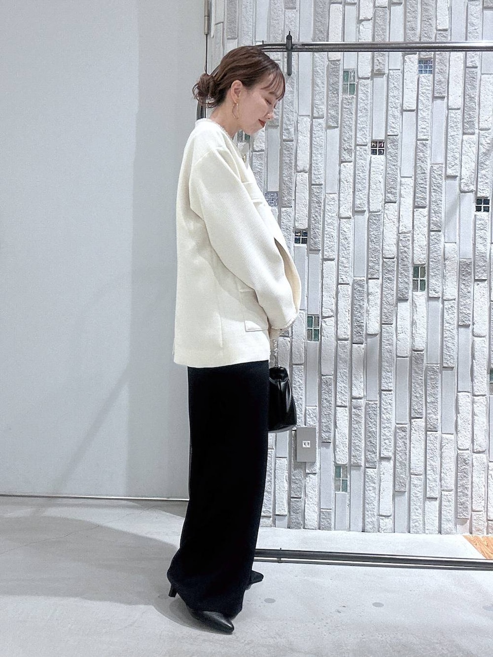 ホワイト系のノーカラージャケット、ブルー系のサロペット/オーバーオール、ブラック系のショルダーバッグを着用したレディースの冬コーディネートの3枚目の写真