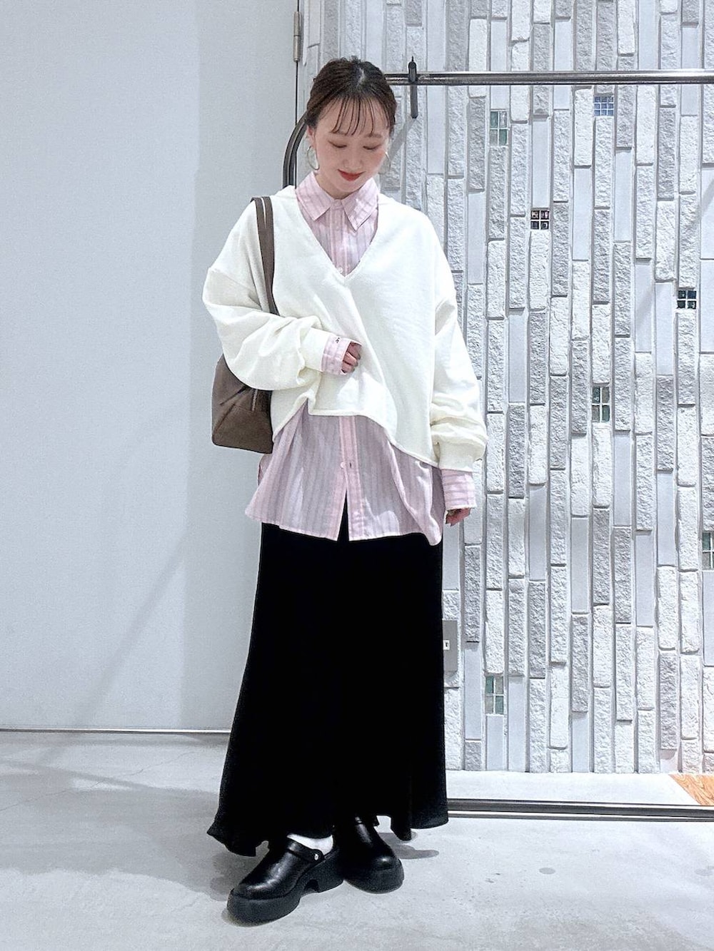 ブラック系のサンダル、ブラウン系のボストンバッグ、ピンク系のシャツ/ブラウスを着用したレディースの冬コーディネートの2枚目の写真