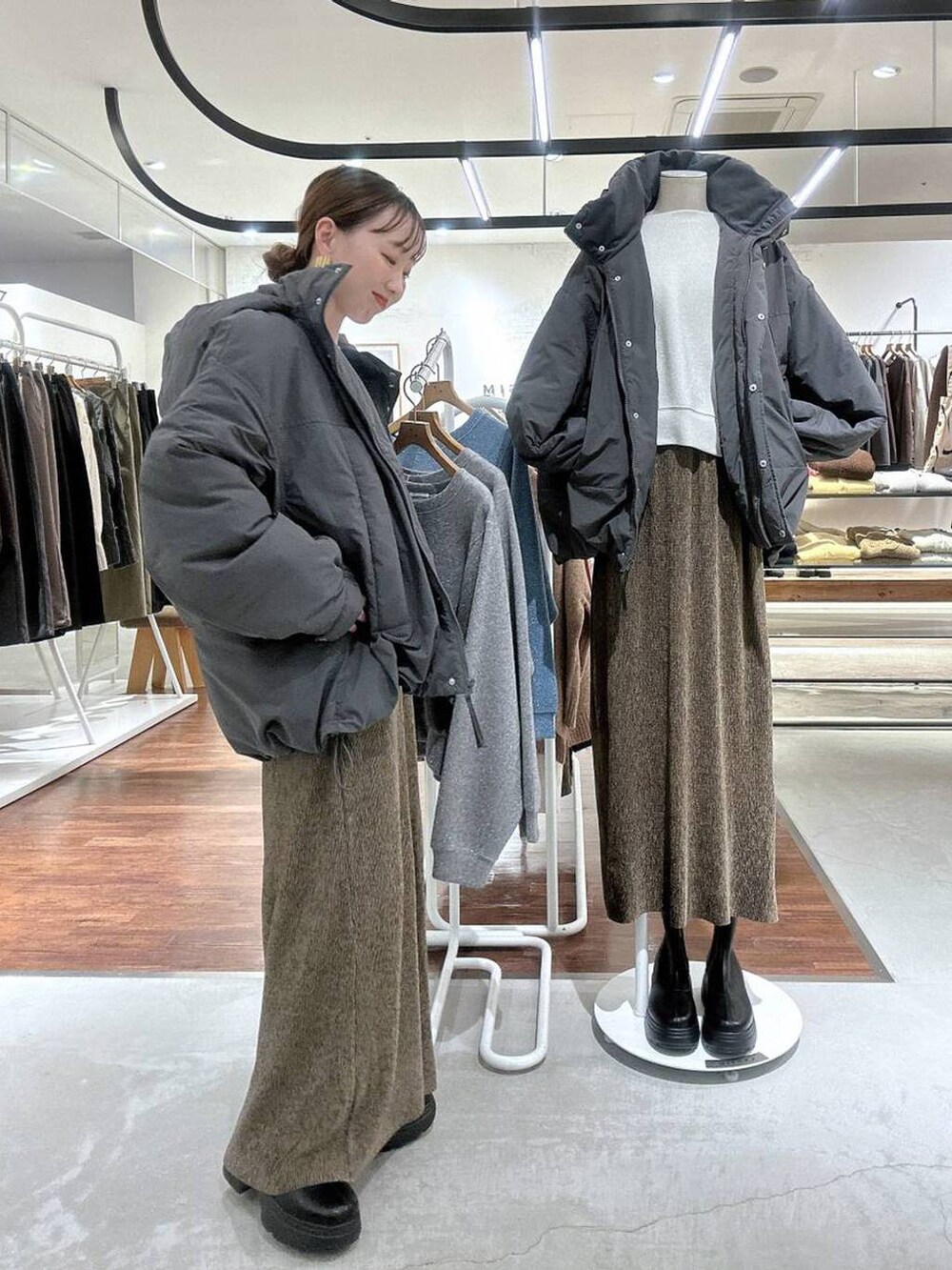 グレー系のその他アウター、ブラック系のブーツ、ホワイト系のTシャツ/カットソーを着用したレディースの冬コーディネートの3枚目の写真