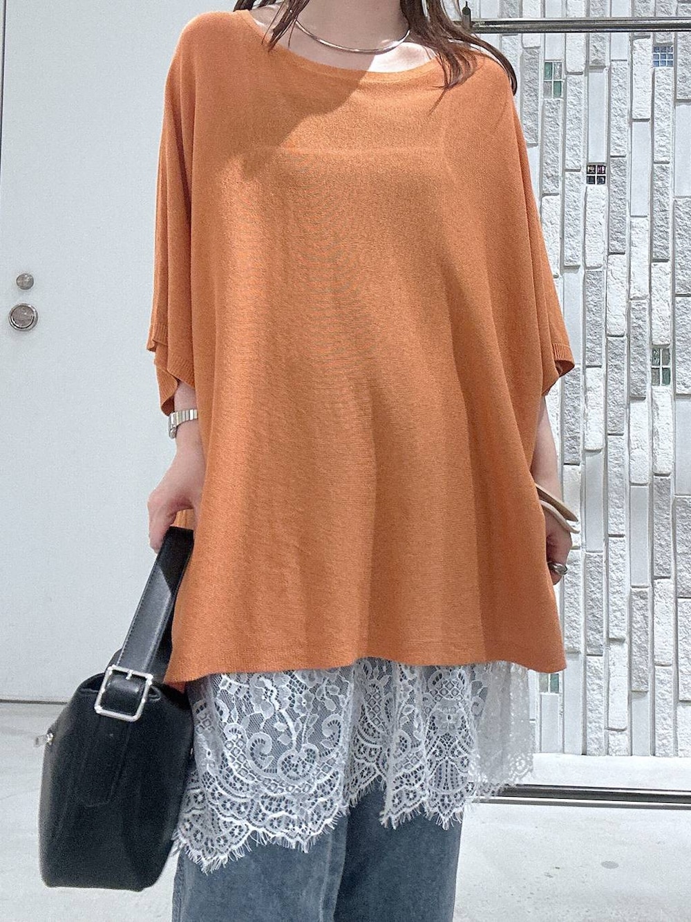 ブルー系のデニムパンツ、ブラウン系のサンダル、ブラック系のショルダーバッグを着用したレディースの夏コーディネートの5枚目の写真