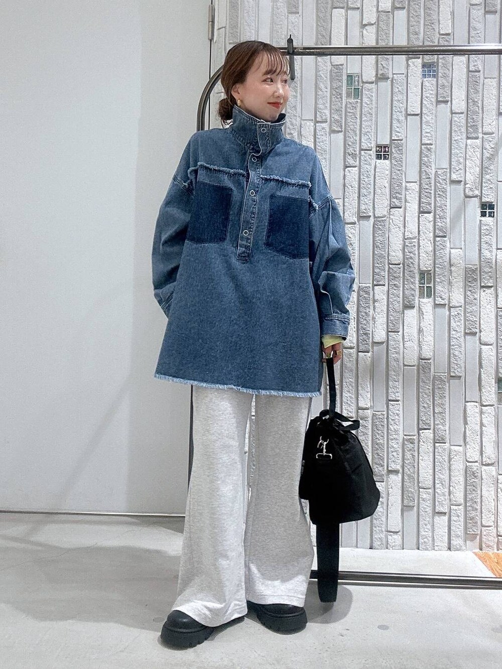 イエロー系のTシャツ/カットソー、ブルー系のシャツ/ブラウス、ブラック系のショルダーバッグを着用したレディースの冬コーディネートの2枚目の写真