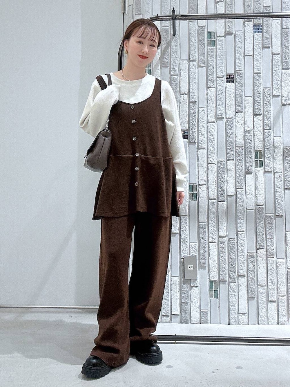 ブラック系のブーツ、ホワイト系のTシャツ/カットソー、ブラウン系のショルダーバッグを着用したレディースの冬コーディネートの2枚目の写真