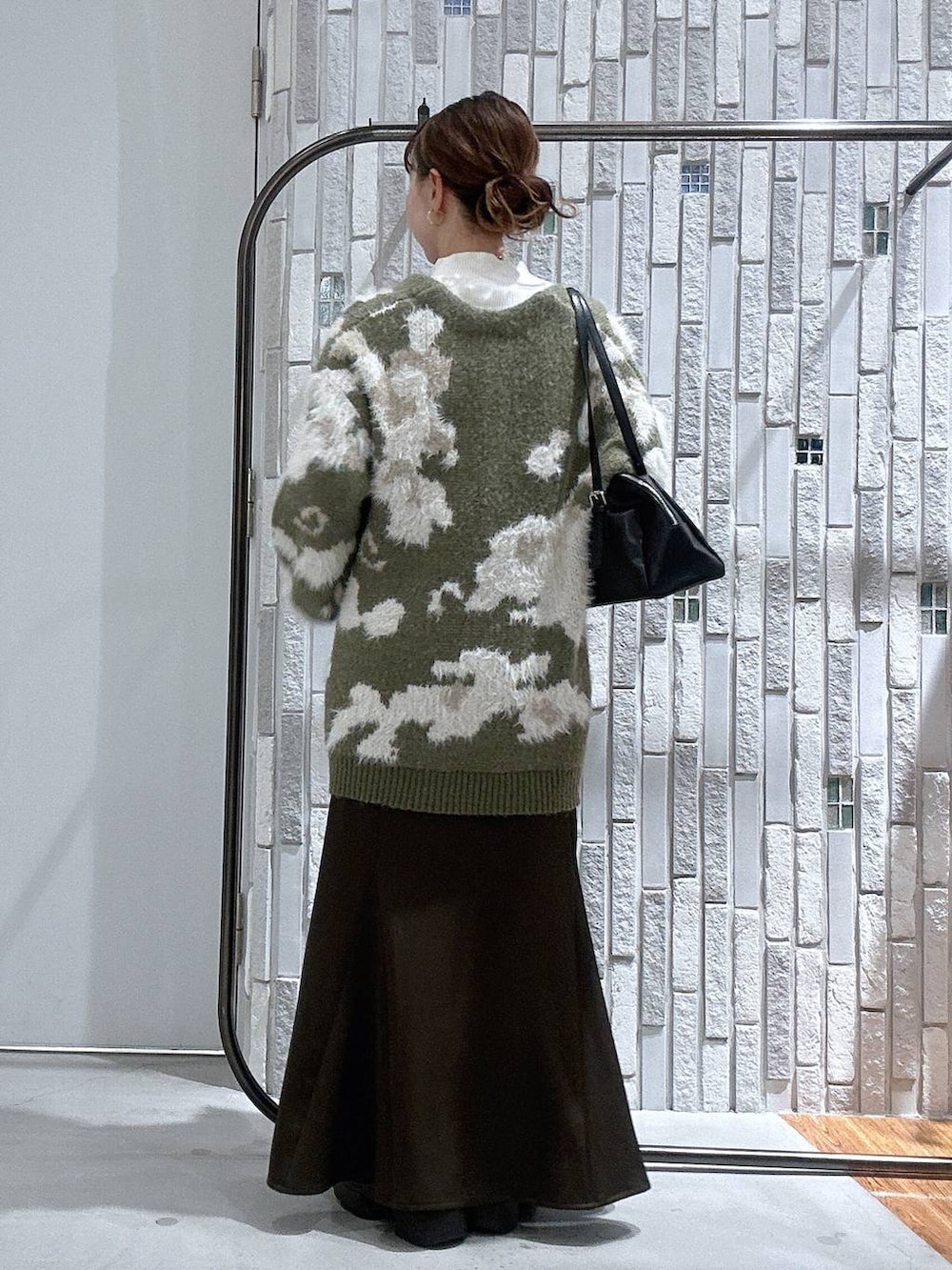 ホワイト系のニット/セーター、ブラック系のボストンバッグ、ブラック系のブーツを着用したレディースの冬コーディネートの4枚目の写真