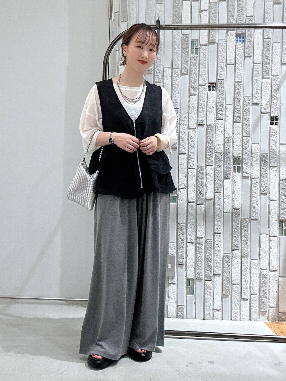 グレー系のその他パンツ、その他のサンダル、シルバー系のショルダーバッグを着用したレディースの春コーディネートの2枚目の写真