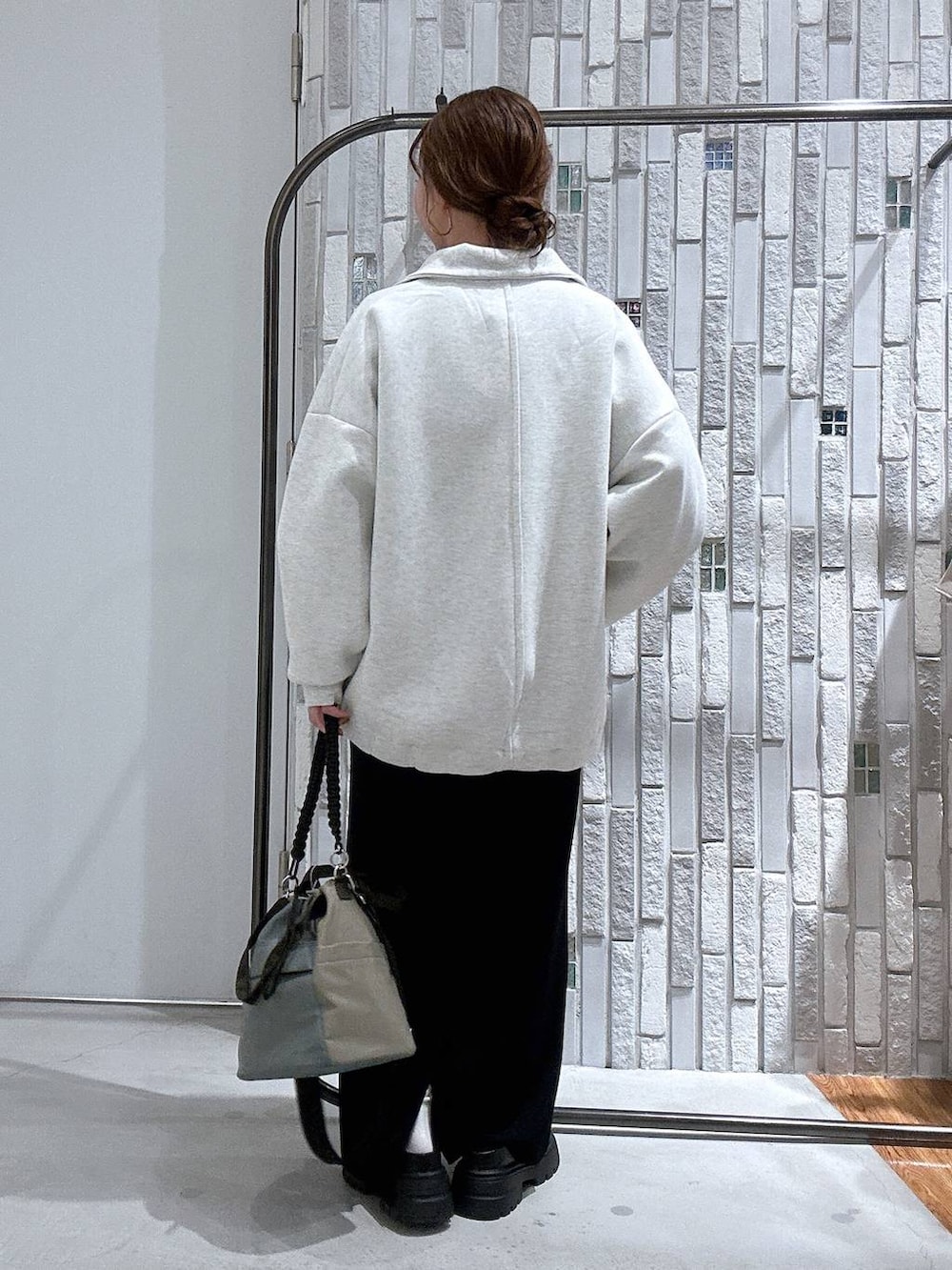 ブラック系のスカート、ブラック系のサンダル、グリーン系のショルダーバッグを着用したレディースの冬コーディネートの4枚目の写真