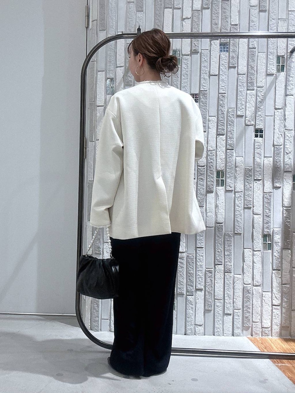 ホワイト系のノーカラージャケット、ブルー系のサロペット/オーバーオール、ブラック系のショルダーバッグを着用したレディースの冬コーディネートの4枚目の写真