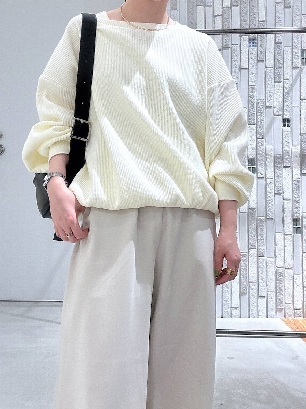 ブラック系のショルダーバッグ、ホワイト系のその他パンツ、ホワイト系のTシャツ/カットソーを着用したレディースの冬コーディネートの5枚目の写真