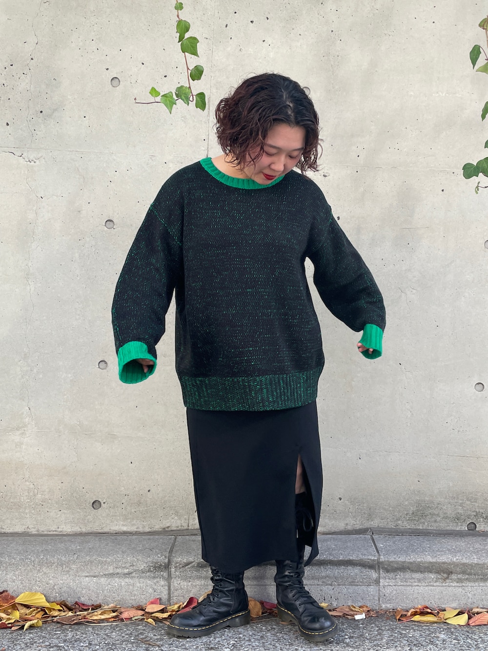 グリーン系のニット/セーターを着用したレディースの秋コーディネートの2枚目の写真