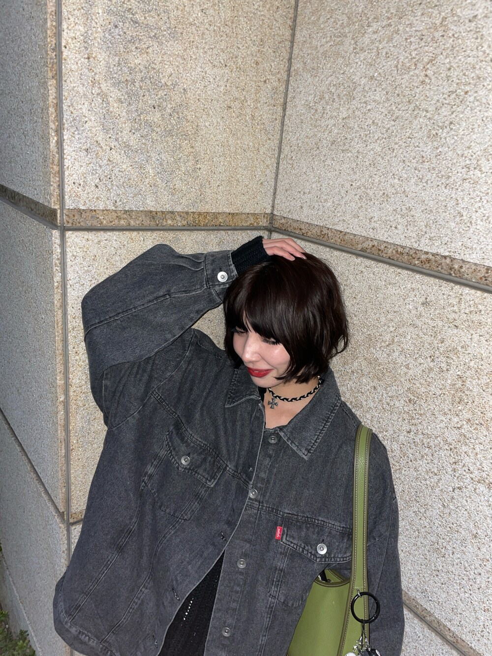 ブラック系のデニムジャケットを着用したレディースの秋コーディネートの2枚目の写真