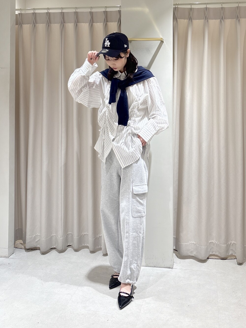 ホワイト系のシャツ/ブラウス、グレー系のその他パンツ、ブルー系のニット/セーターを着用したレディースの春コーディネートの3枚目の写真