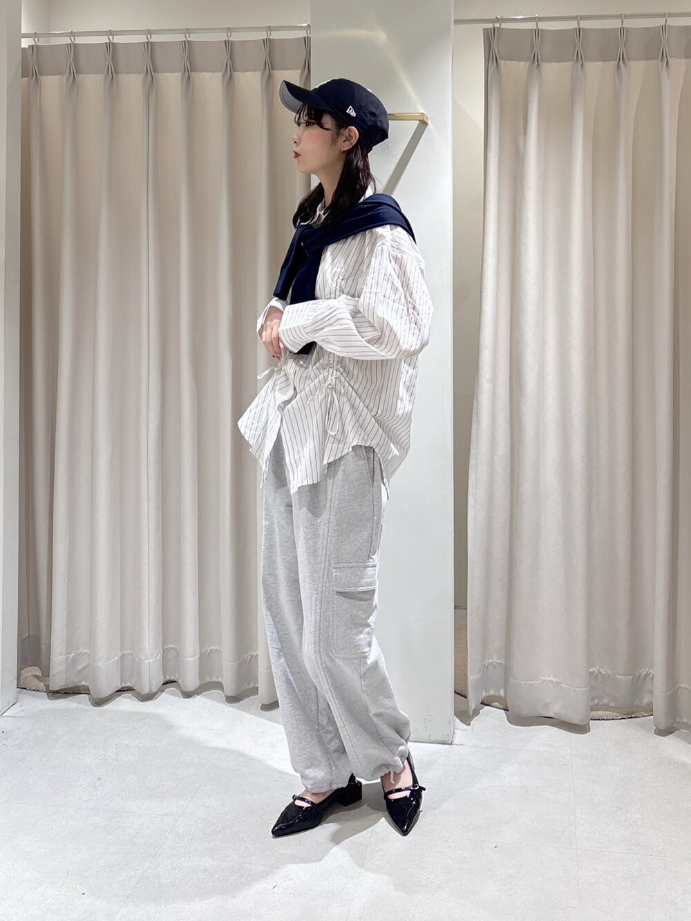 ホワイト系のシャツ/ブラウス、グレー系のその他パンツ、ブルー系のニット/セーターを着用したレディースの春コーディネートの2枚目の写真