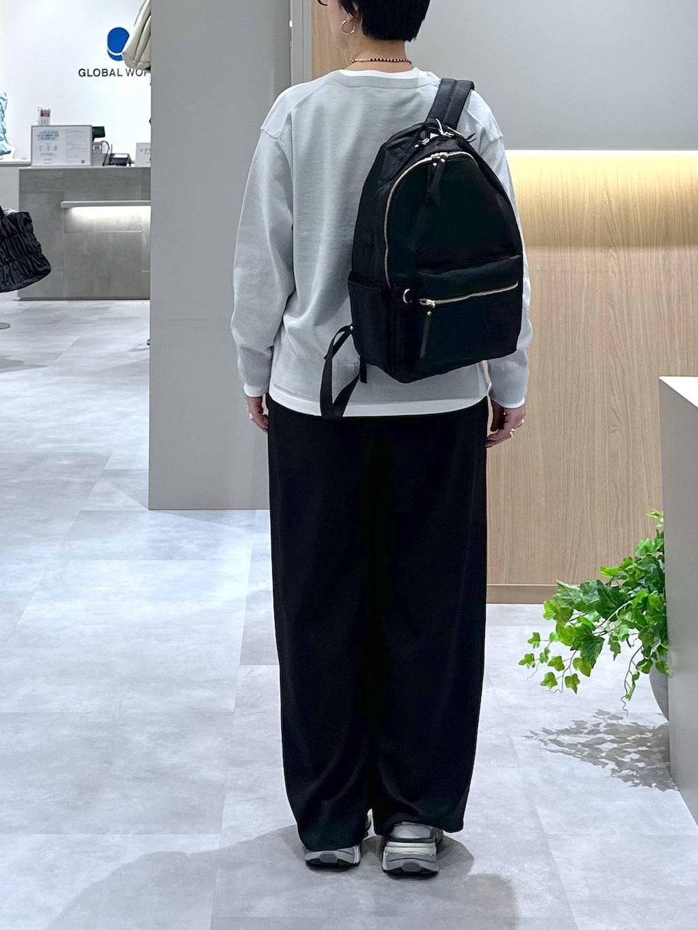 ブラック系のバックパック/リュック、ブラック系のその他パンツ、グレー系のニット/セーターを着用したレディースの春コーディネートの3枚目の写真