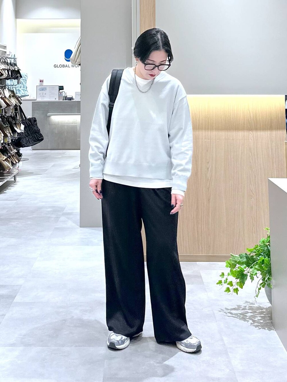 ブラック系のバックパック/リュック、ブラック系のその他パンツ、グレー系のニット/セーターを着用したレディースの春コーディネートの5枚目の写真