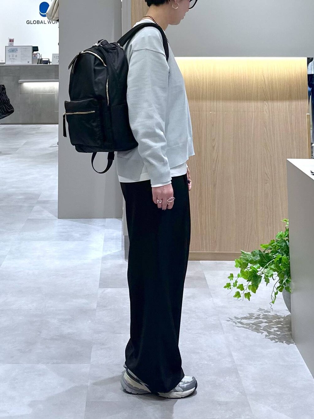 ブラック系のバックパック/リュック、ブラック系のその他パンツ、グレー系のニット/セーターを着用したレディースの春コーディネートの4枚目の写真