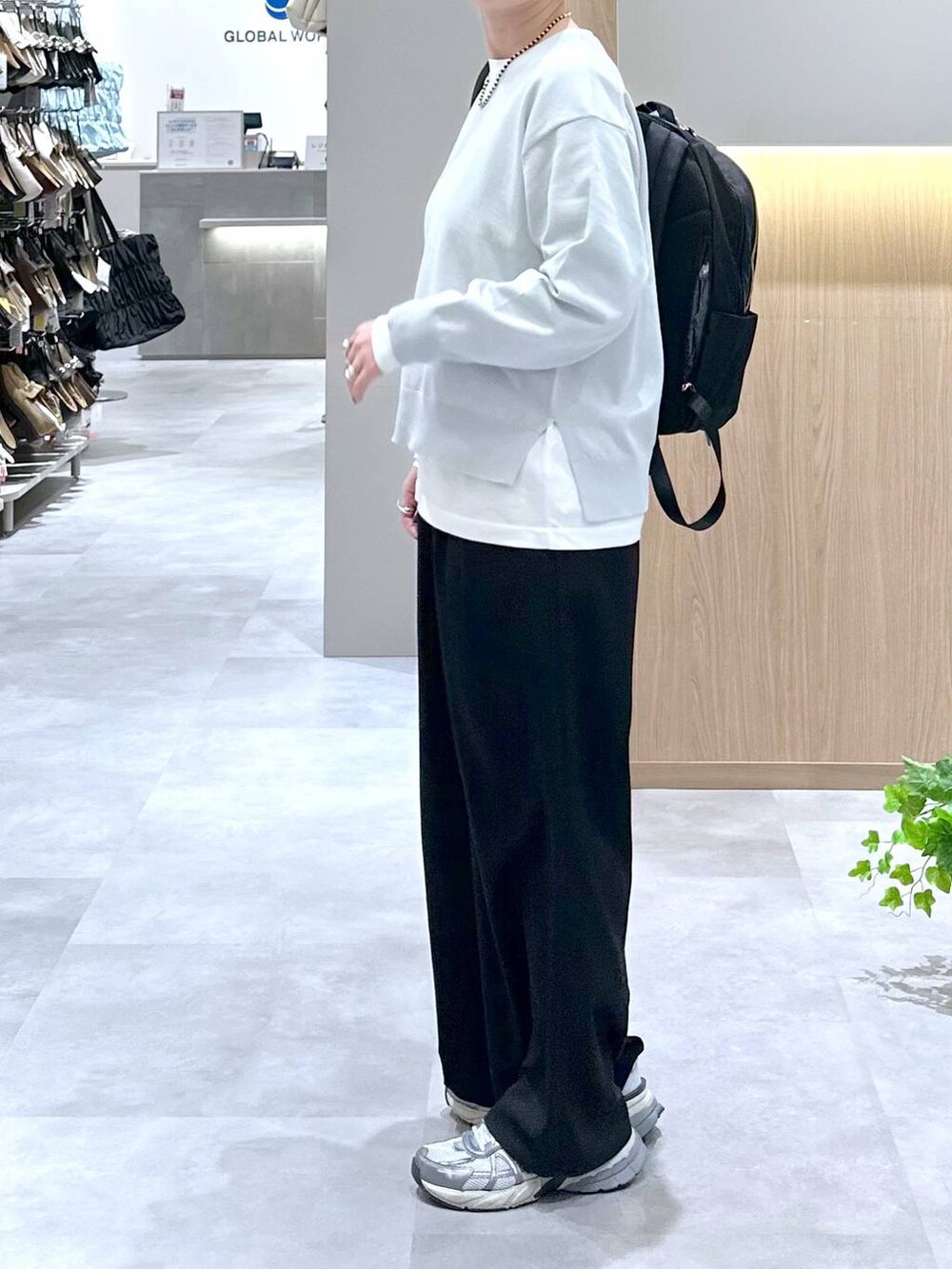 ブラック系のバックパック/リュック、ブラック系のその他パンツ、グレー系のニット/セーターを着用したレディースの春コーディネートの2枚目の写真