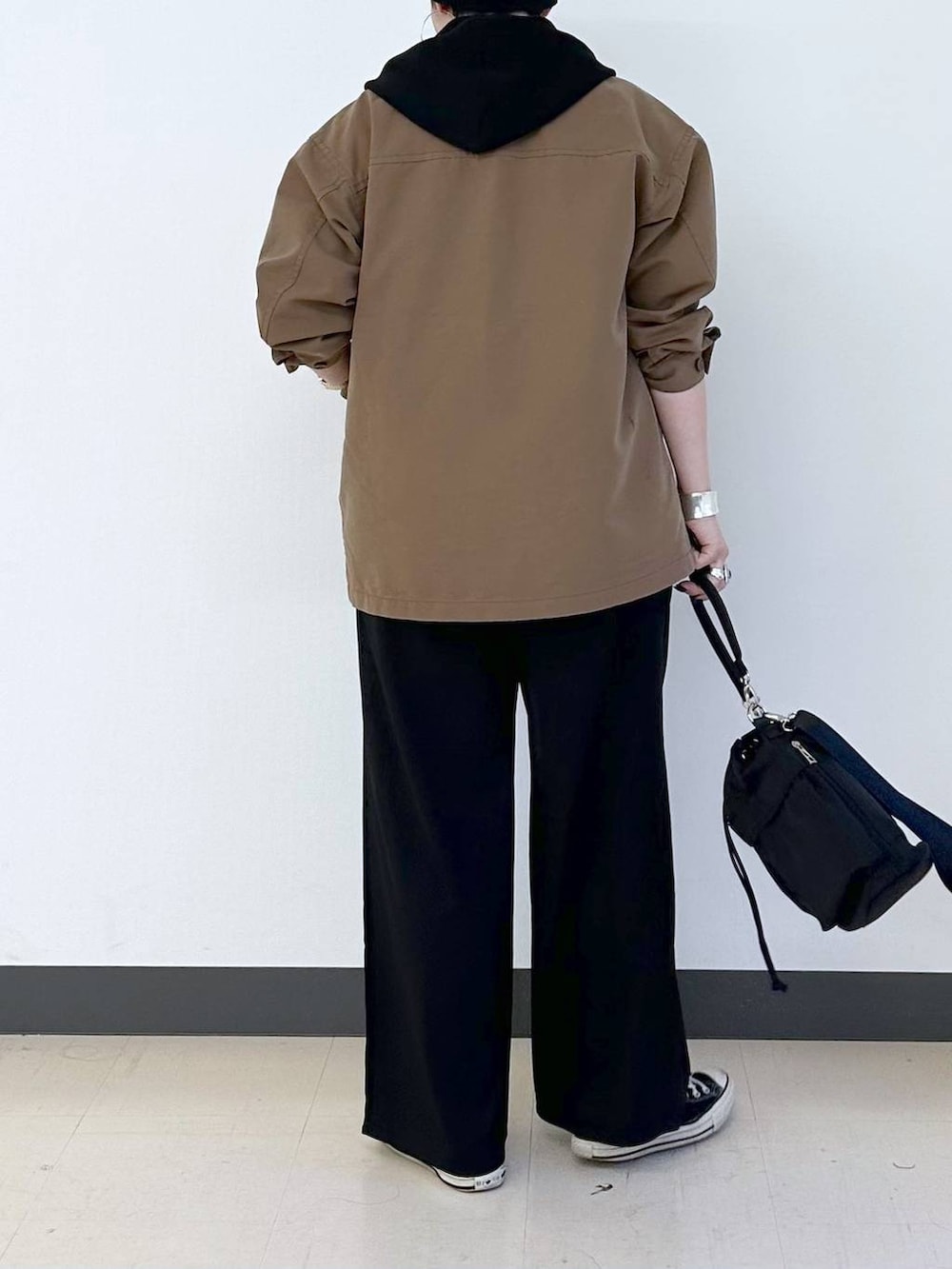 ブラック系のショルダーバッグ、ブラック系のその他パンツ、ブラウン系のデニムジャケットを着用したレディースの春コーディネートの3枚目の写真