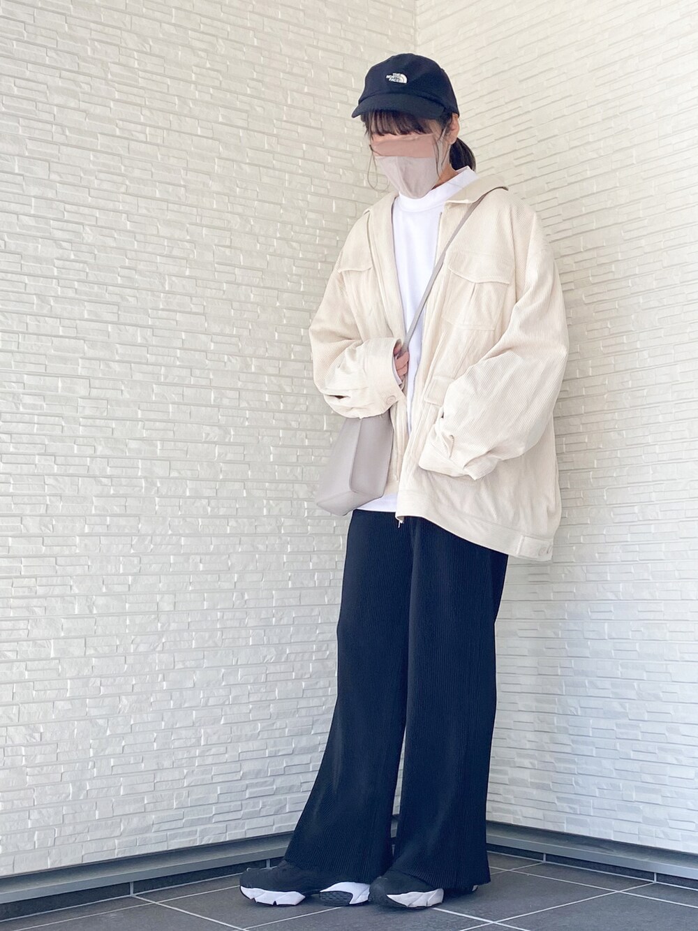 ホワイト系のブルゾン、ホワイト系のTシャツ/カットソー、ブラック系のその他パンツを着用したレディースの秋コーディネートの2枚目の写真