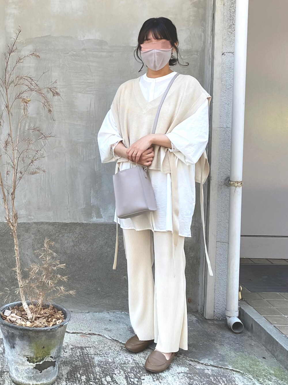 ホワイト系のシャツ/ブラウス、ベージュ系のベスト、ベージュ系のパンツを着用したレディースの春コーディネートの2枚目の写真