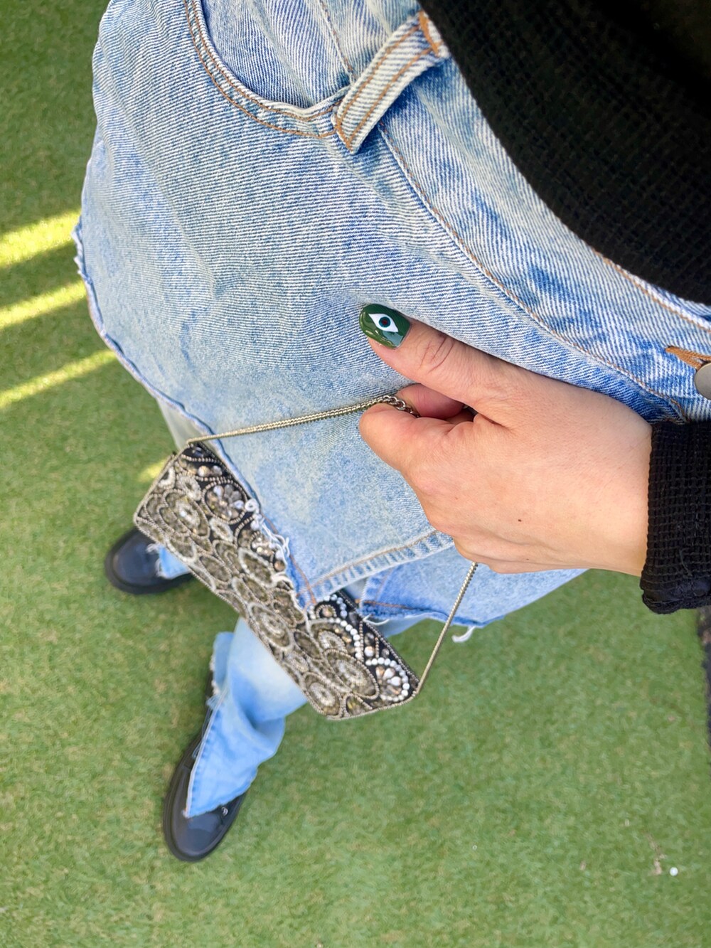 ブラック系のTシャツ/カットソー、ブルー系のデニムパンツ、ブラック系のスニーカーを着用したレディースの秋コーディネートの3枚目の写真