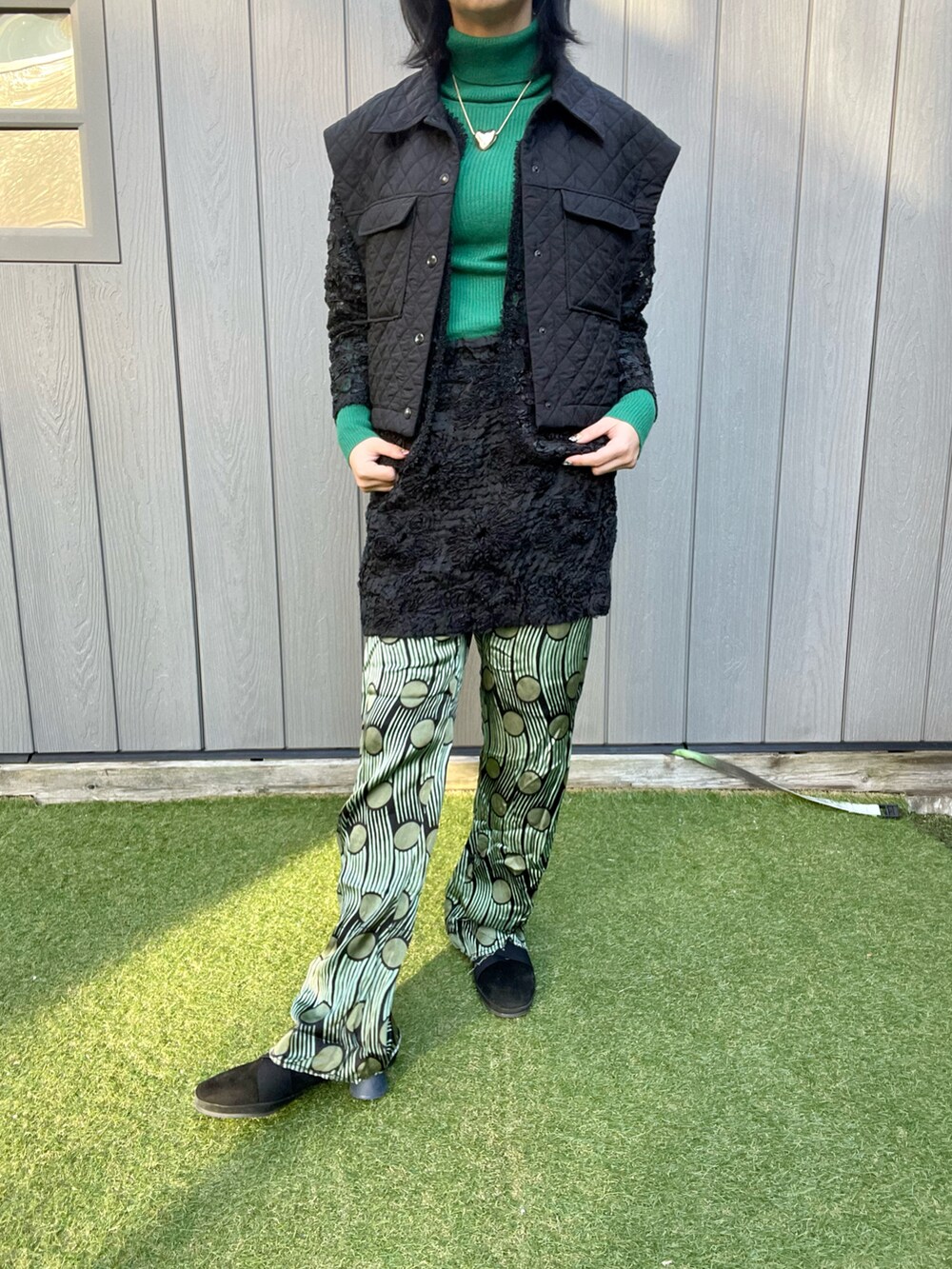 ブラック系のベスト、ブラック系のスカート、グリーン系のその他パンツを着用したレディースの秋コーディネートの2枚目の写真