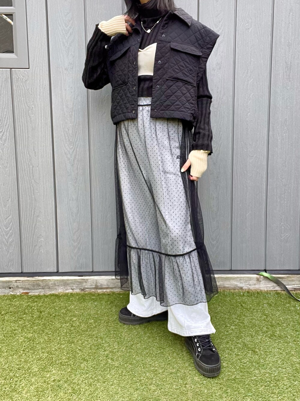 ブラック系のベスト、ブラック系のワンピース、グレー系のスウェットパンツを着用したレディースの冬コーディネートの3枚目の写真