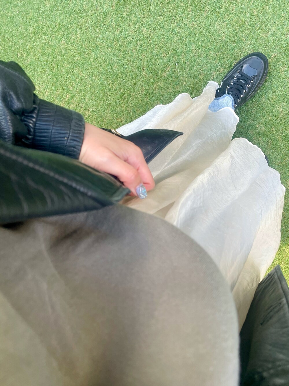 ブラック系のジャケット/アウター、グリーン系のスウェット、ベージュ系のスカートを着用したレディースの冬コーディネートの3枚目の写真