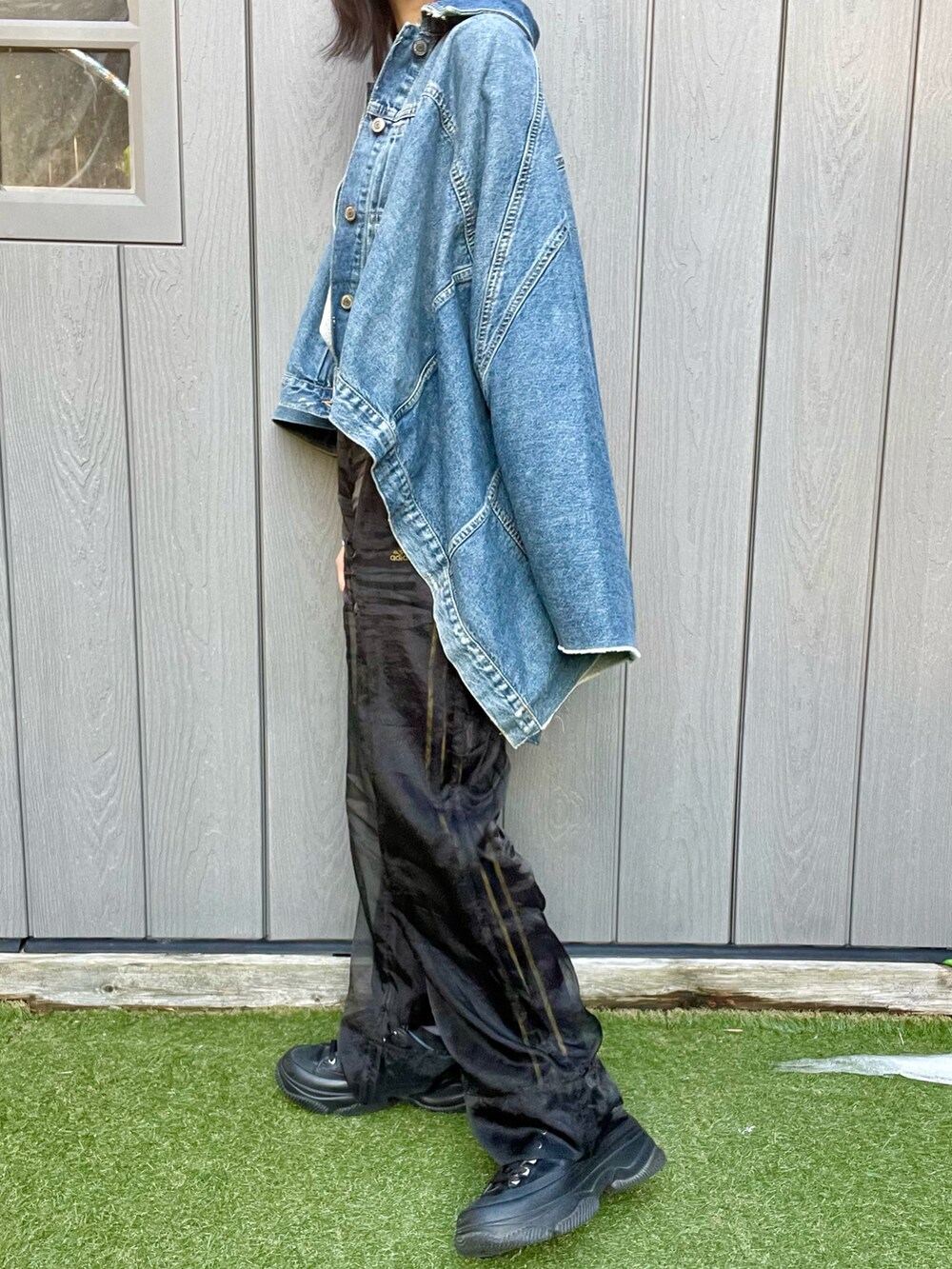 ブラック系のパンツ、ブルー系のデニムジャケット、シルバー系のニット/セーターを着用したレディースの冬コーディネートの2枚目の写真