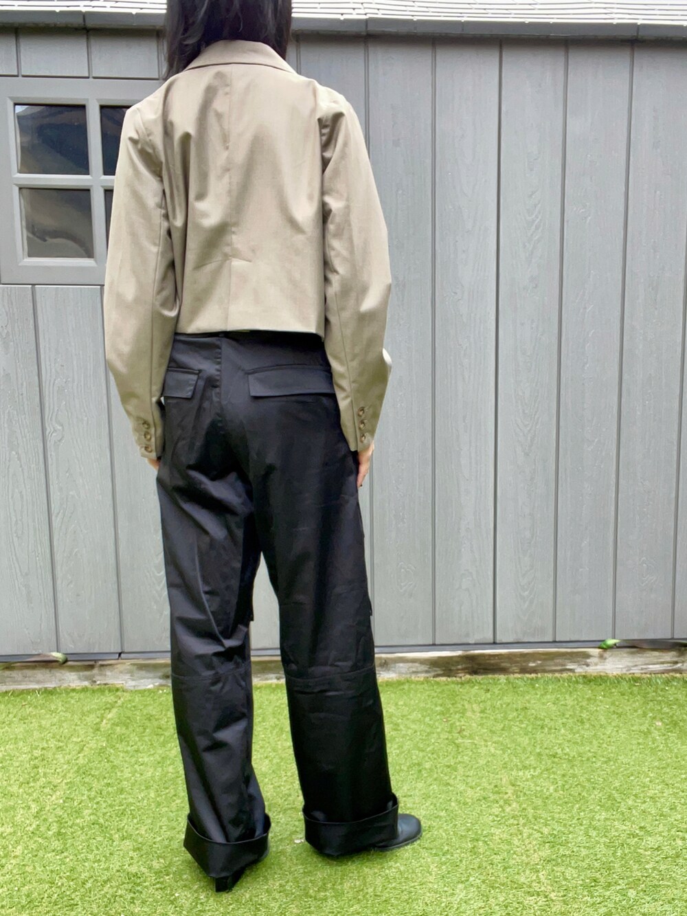 ブラック系のスリッポン、ブラック系のカーゴパンツ、ベージュ系のテーラードジャケットを着用したレディースの秋コーディネートの4枚目の写真