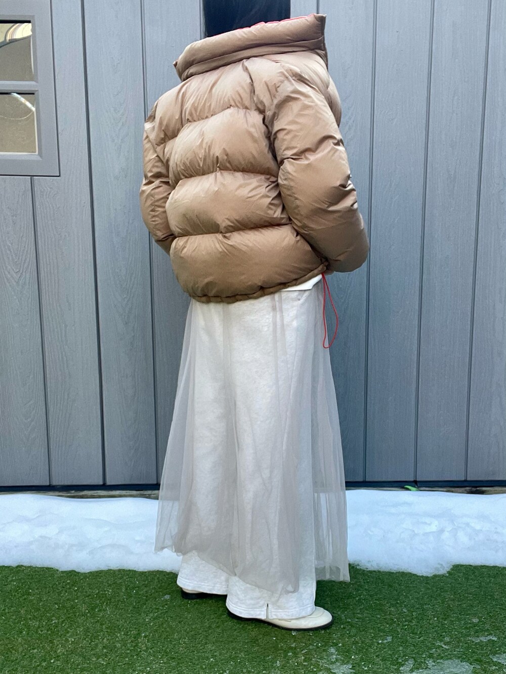 ベージュ系のスカート、グレー系のスウェットパンツ、ホワイト系のローファーを着用したレディースの冬コーディネートの3枚目の写真