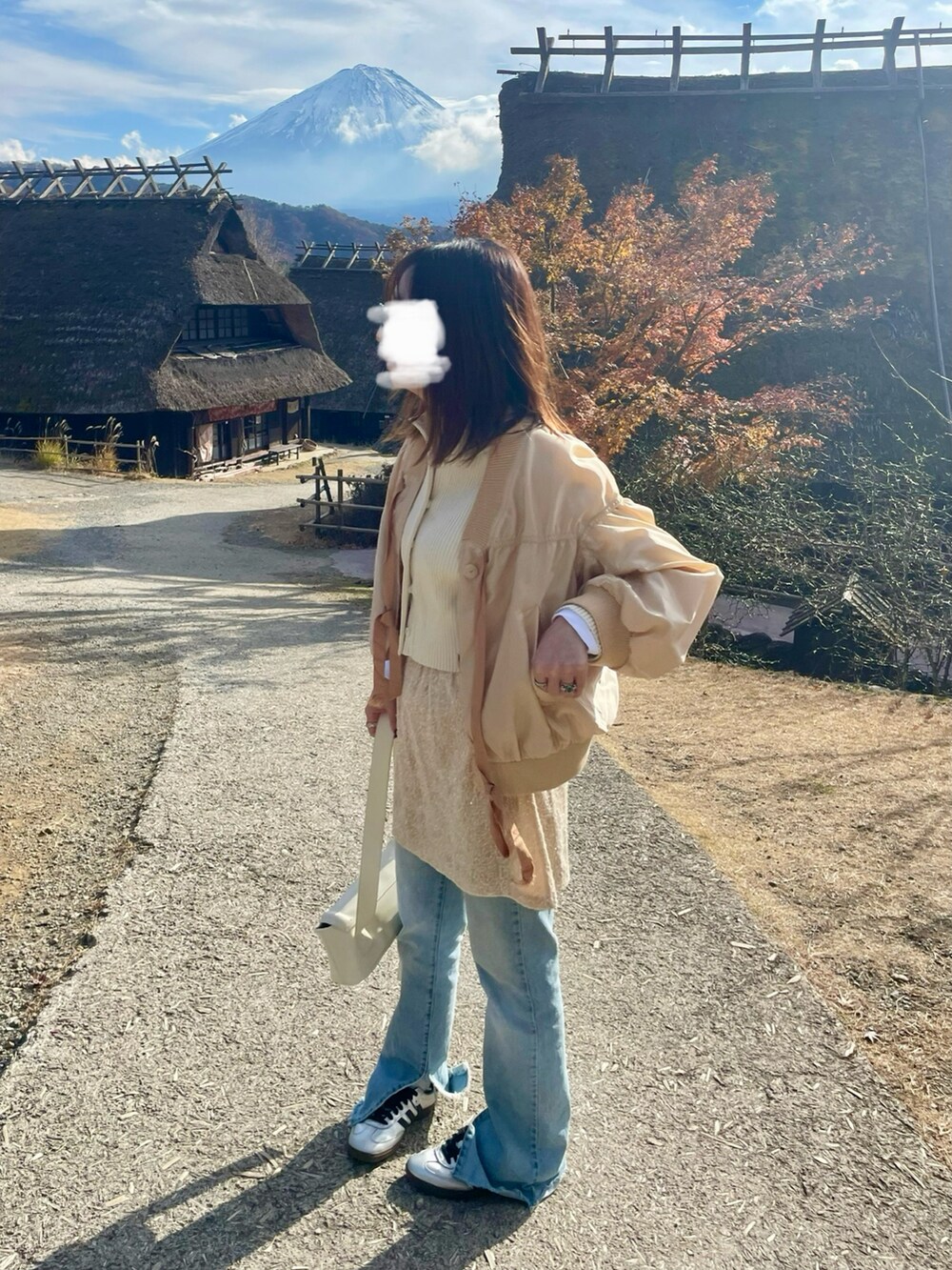 ホワイト系のカーディガン/ボレロ、その他のスカート、ブルー系のデニムパンツを着用したレディースの冬コーディネートの2枚目の写真