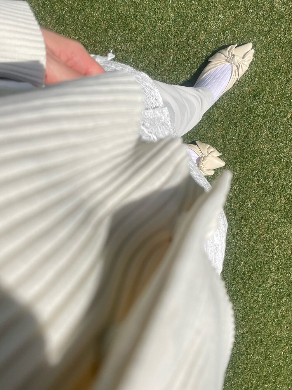 ホワイト系のカーディガン/ボレロ、ホワイト系のパンツ、ベージュ系のパンツを着用したレディースの春コーディネートの2枚目の写真