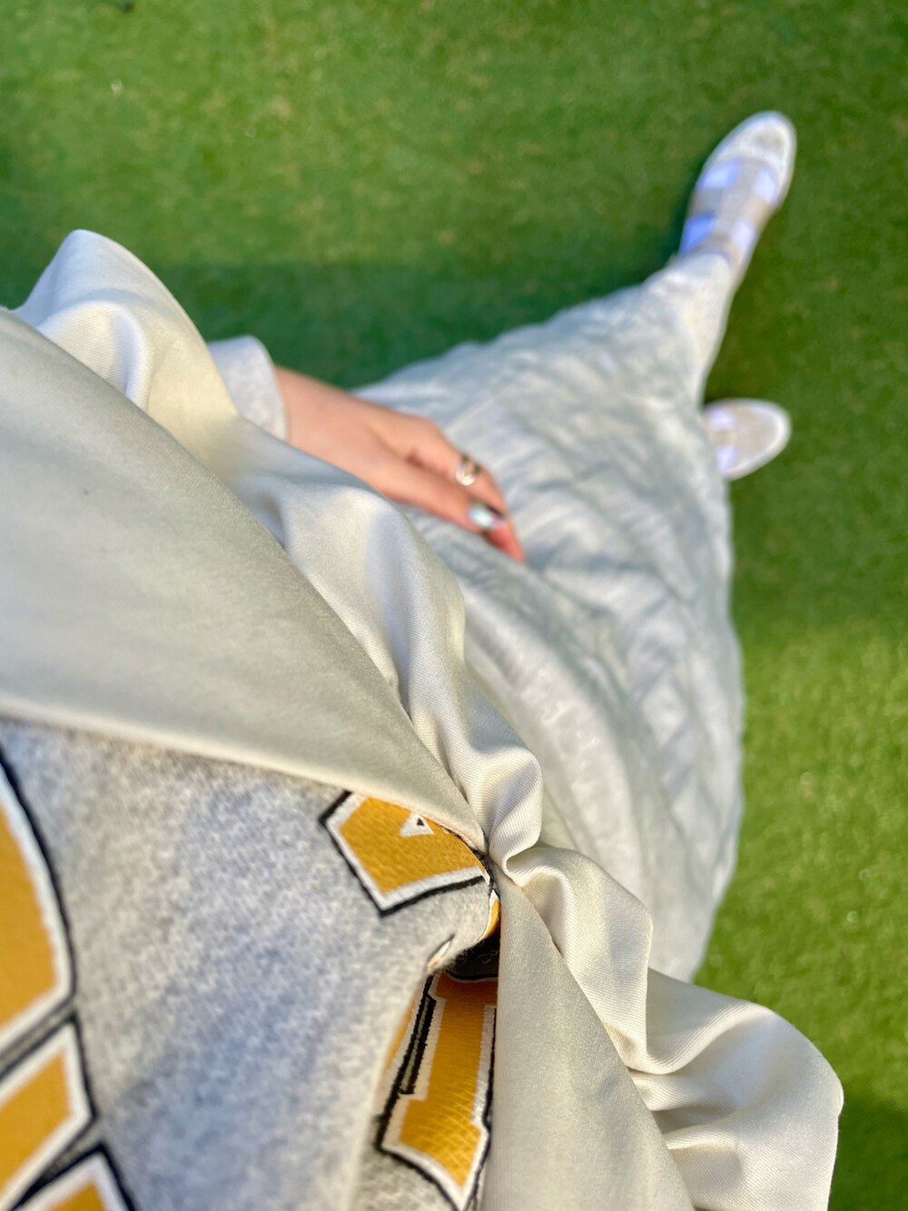 シルバー系のスカート、ホワイト系のその他シューズ、ベージュ系のキャミソールを着用したレディースの冬コーディネートの4枚目の写真