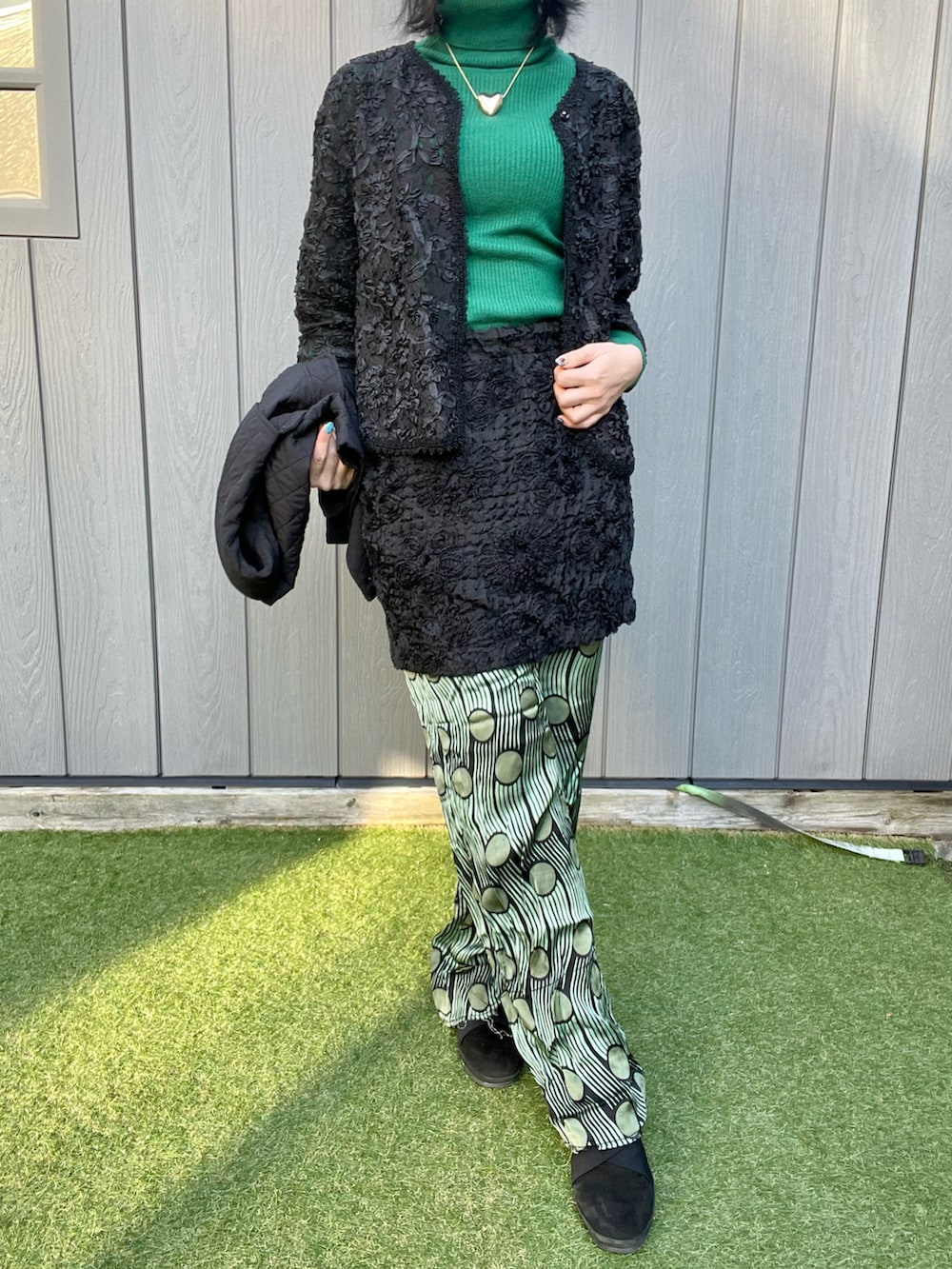 ブラック系のベスト、ブラック系のスカート、グリーン系のその他パンツを着用したレディースの秋コーディネートの4枚目の写真