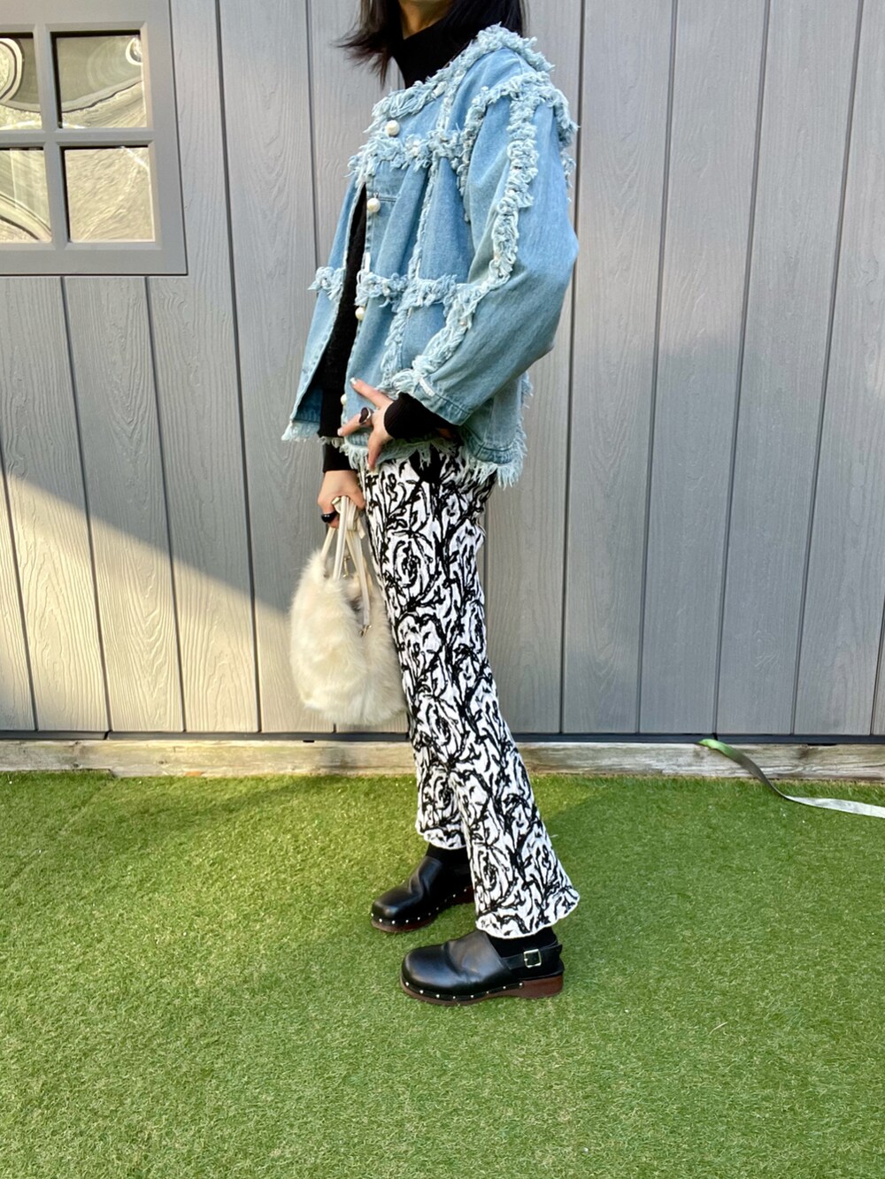 ホワイト系のトートバッグ、ホワイト系のパンツ、ブルー系のデニムジャケットを着用したレディースの冬コーディネートの2枚目の写真