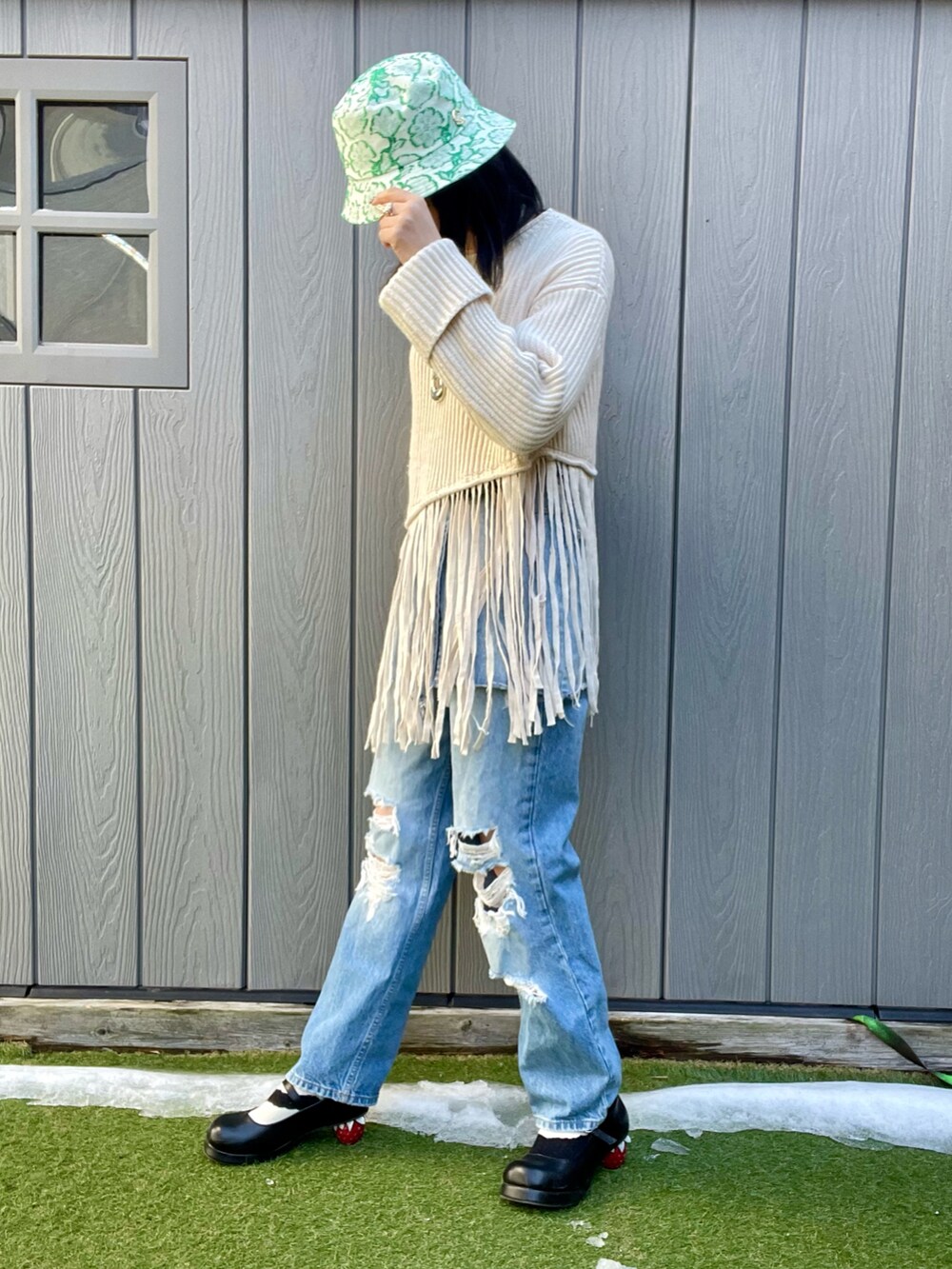 ブルー系のデニムパンツ、ホワイト系のニット/セーター、ブラック系のその他シューズを着用したレディースの冬コーディネートの2枚目の写真