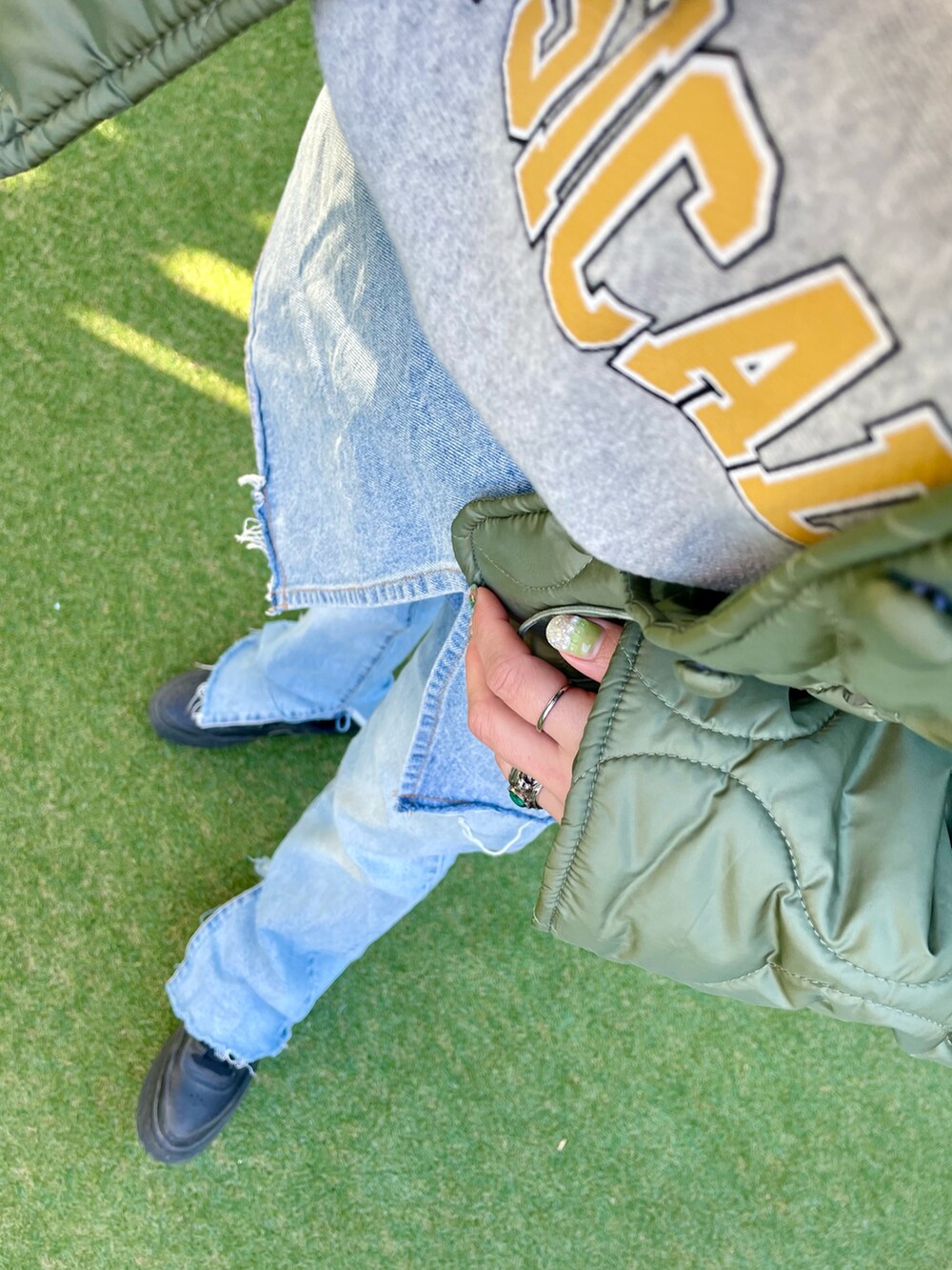 ブルー系のデニムパンツ、ブラック系のスニーカー、グリーン系のその他アウターを着用したレディースの冬コーディネートの3枚目の写真