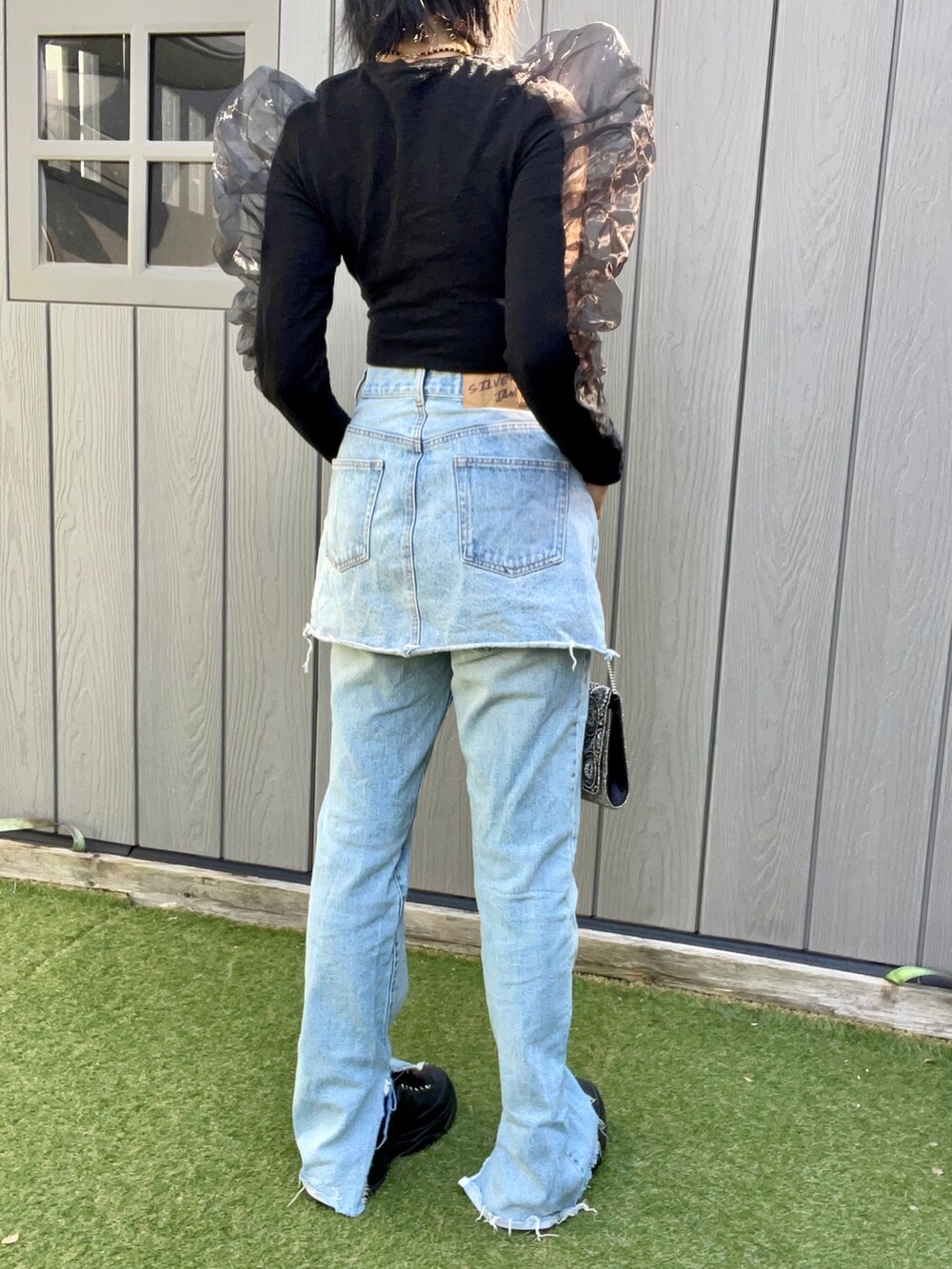 ブラック系のTシャツ/カットソー、ブルー系のデニムパンツ、ブラック系のスニーカーを着用したレディースの秋コーディネートの2枚目の写真