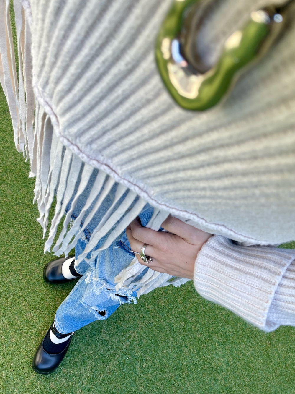 ブルー系のデニムパンツ、ホワイト系のニット/セーター、ブラック系のその他シューズを着用したレディースの冬コーディネートの3枚目の写真